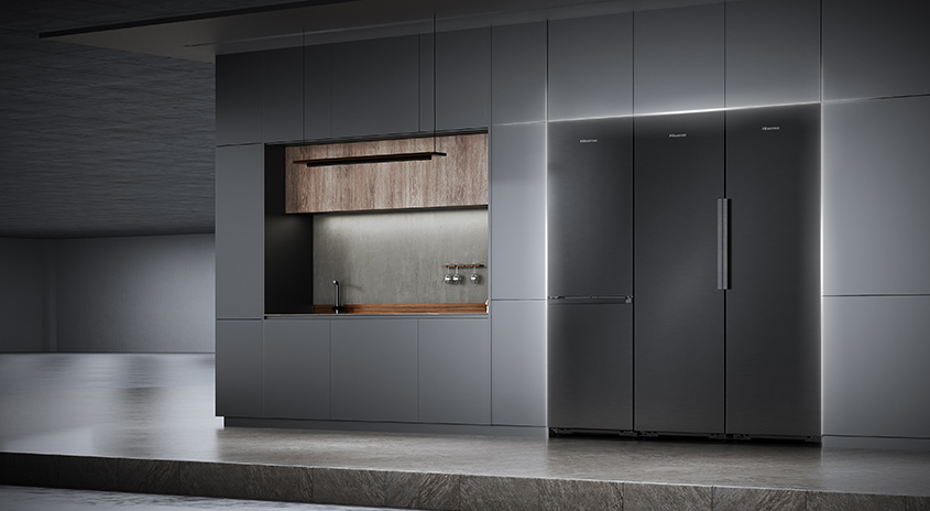 Eine moderne Küche mit grauen Schränken, einer Holzarbeitsplatte und einem großen, dreitürigen Kühlschrank. Beleuchtung betont die klaren Linien.