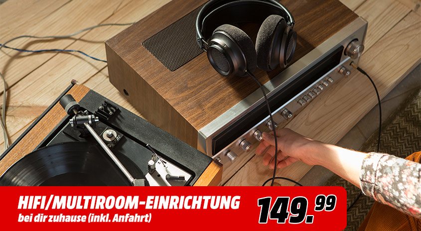 Holzregal mit Plattenspieler, Kopfhörern und silbernem Verstärker auf Holzboden. Hand bedient Verstärker.