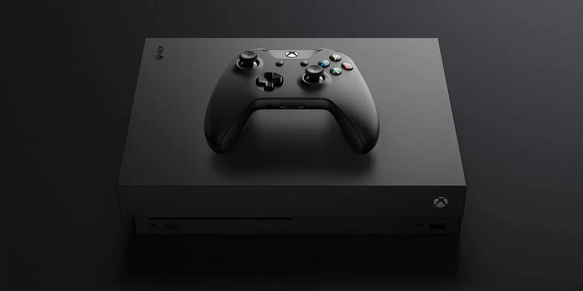 Xbox One mit passendem schwarzen Gamecontroller auf dunklem Untergrund