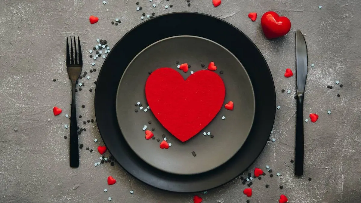 Schwarzer Teller mit rotem Herz in der Mitte und kleinen roten Herzchen drumherum.