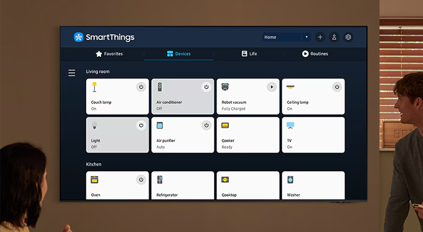 Ein SmartThings-Dashboard auf einem Bildschirm zeigt verbundene Geräte wie Lampen, Klimaanlage, Staubsauger und Fernseher.