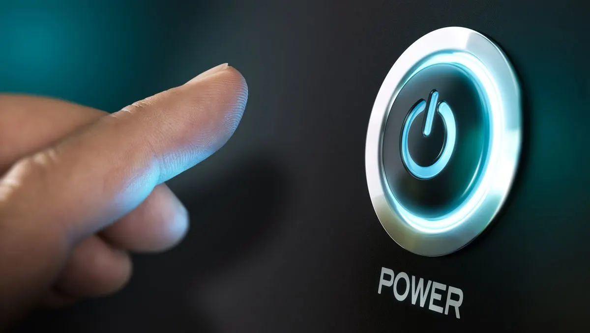 Finger nähert sich einem blau leuchtenden Power-Knopf mit silbernem Rand auf dunkler Fläche. Darunter der Schriftzug "POWER".