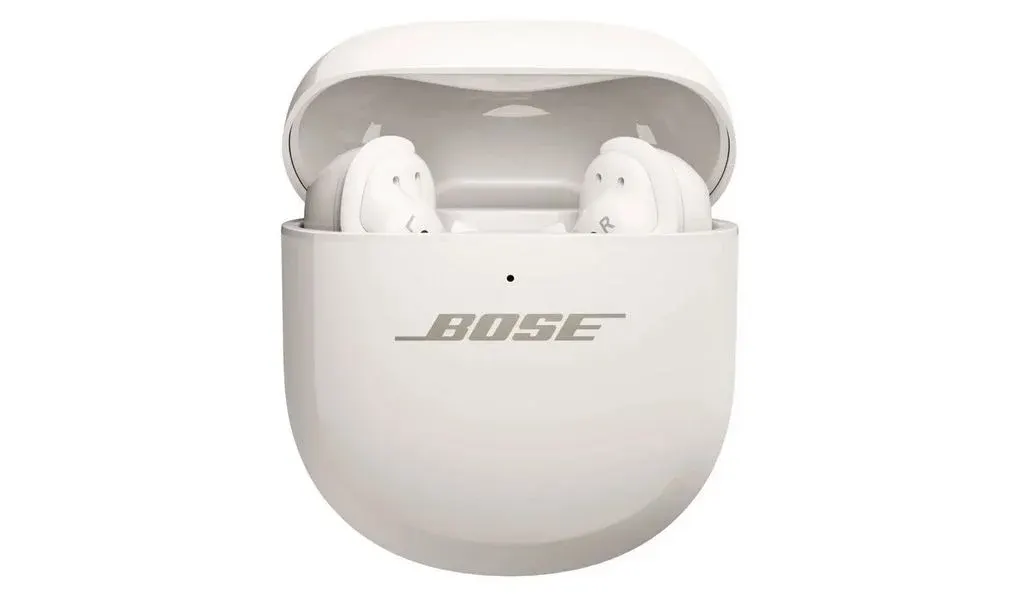 Ein Paar weiße Bose In-Ear-Kopfhörer, die in ihrem geöffneten weißen Ladecase stecken.