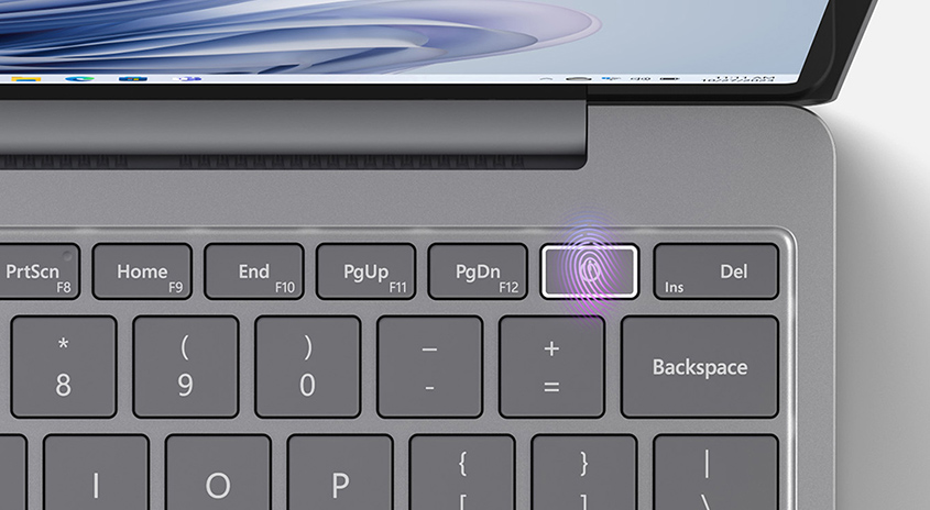 Nahaufnahme einer grauen Laptop-Tastatur mit Fingerabdruckscanner. Die Tasten sind quadratisch mit weißer Beschriftung.