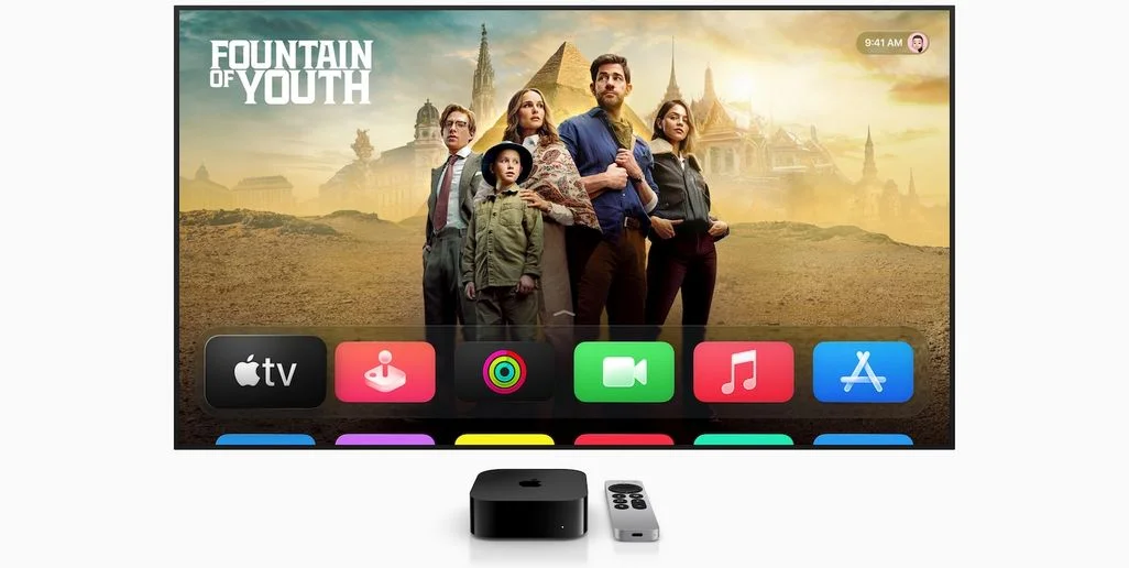 TV zeigt "Fountain of Youth" Filmplakat mit fünf Personen vor Wüstenruinen. Darunter sind App-Symbole. Eine Apple TV Box und Fernbedienung liegen davor.