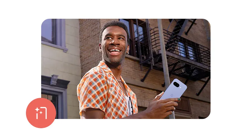 Ein Mann hält ein hellblaues Telefon vor einem Gebäude mit einer Feuerleiter.