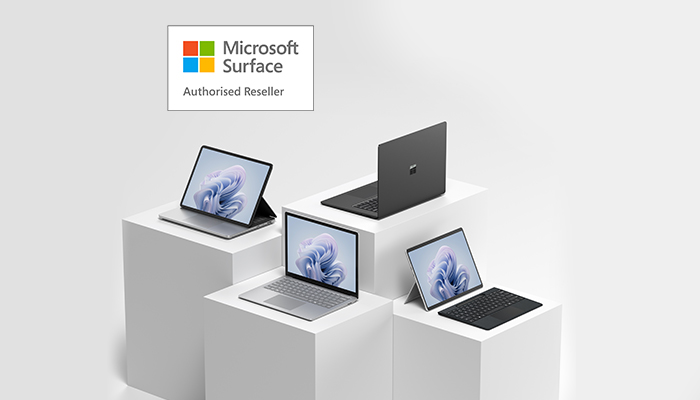 Auf weißem Hintergrund befinden sich mehrere Microsoft Surface-Geräte auf weißen Sockeln. Ein Logo ist in der Ecke.