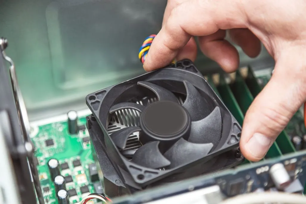 Person haelt CPU-Luefter waehrend Computer-Reparatur oder Wartung in der Hand