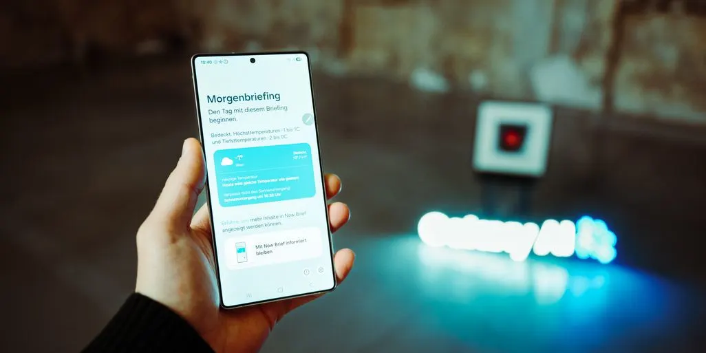 Hand haelt ein Samsung Galaxy S25 Smartphone mit geöffneter Morgenbriefing App.