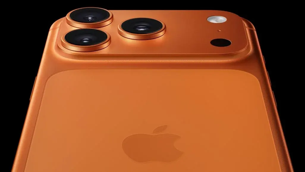 Kupferfarbenes iPhone 17 von hinten. Oben links drei Kameralinsen mit Ringen, ein weißer Blitz und schwarzer Sensor. Apple-Logo mittig.