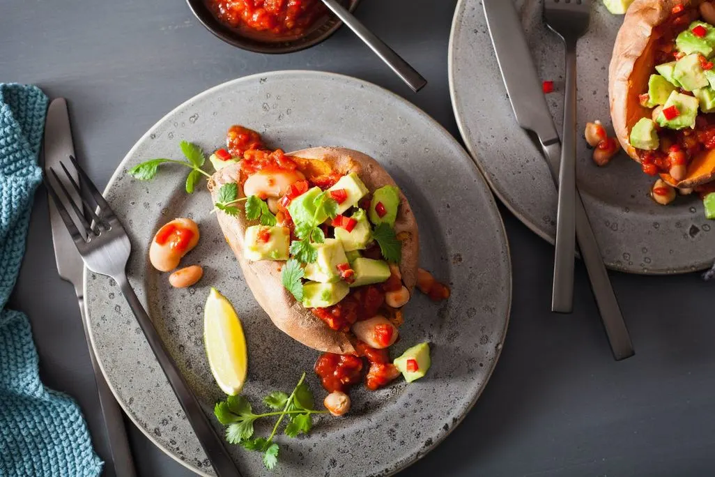 Ofensüßkartoffel gefüllt mit Bohnen, Avocado, Tomatensalsa und Koriander.