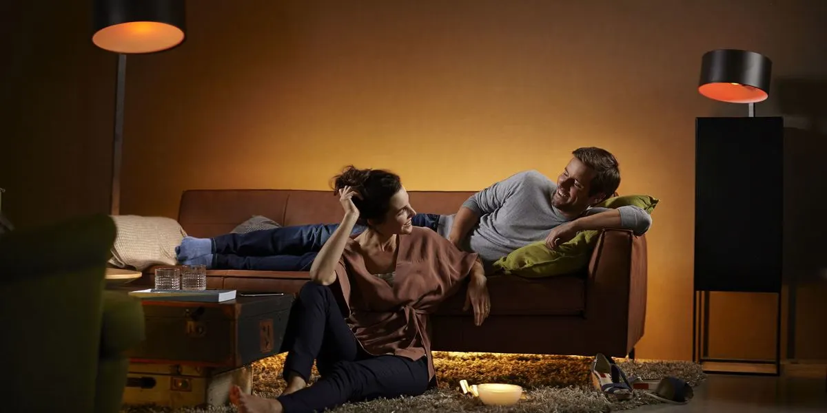 Ein Mann und eine Frau sitzen im Wohnzimmer, der Raum ist angenehm indirekt  beleuchtet