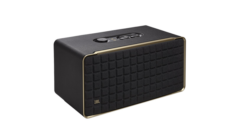 Ein schwarzer Lautsprecher mit quadratischem Muster und goldenen Akzenten steht auf einem weißen Hintergrund.