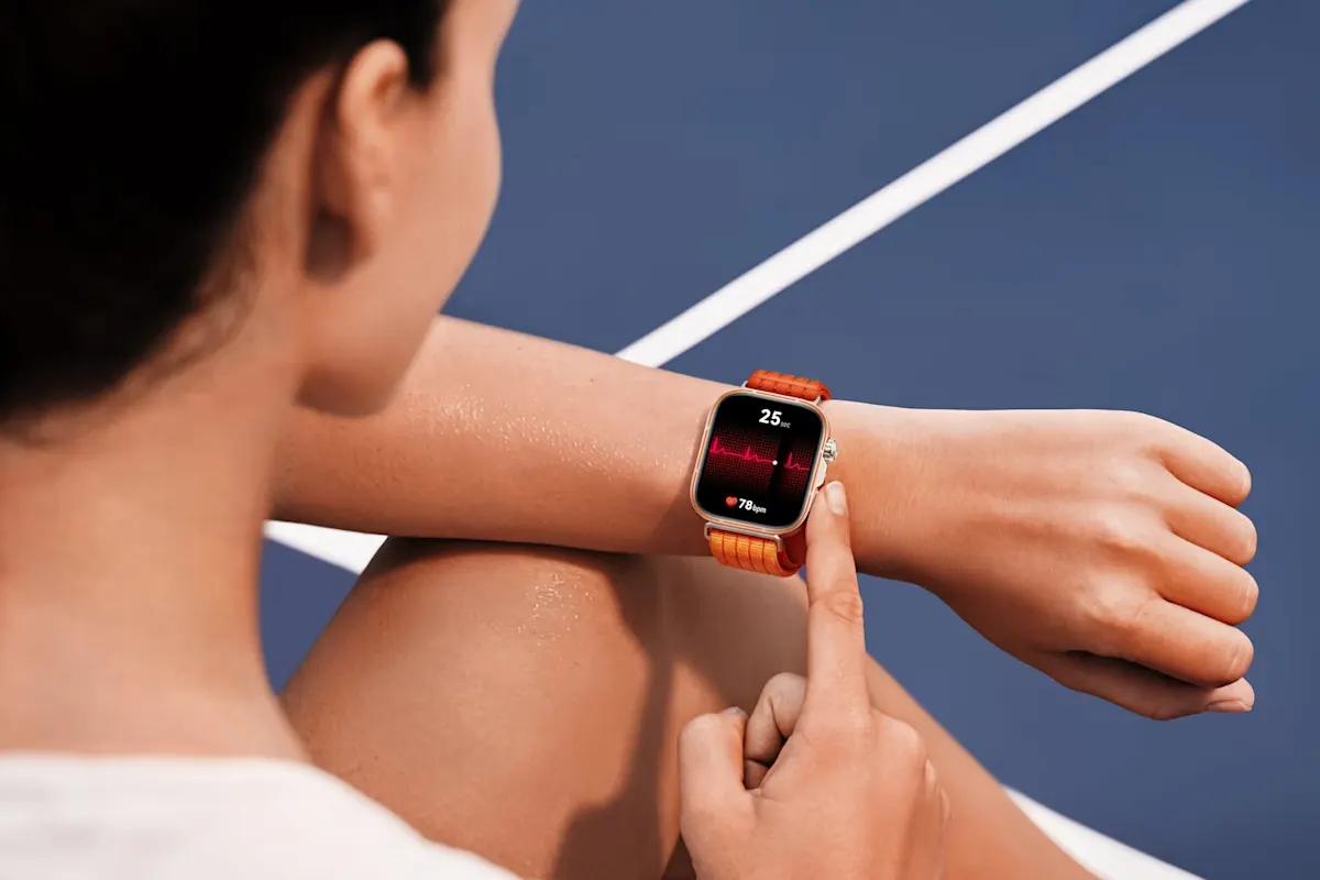 Eine Person sitzt auf einer blauen Laufbahn und hat den Unterarm am Knie abgelegt. Am Handgelenk sitzt eine Huawei Watch Fit 5 Pro, die per Finger bedient wird.
