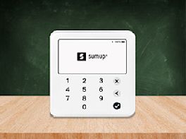 Ein mobiles Bezahlsystem steht auf einem Holztisch.