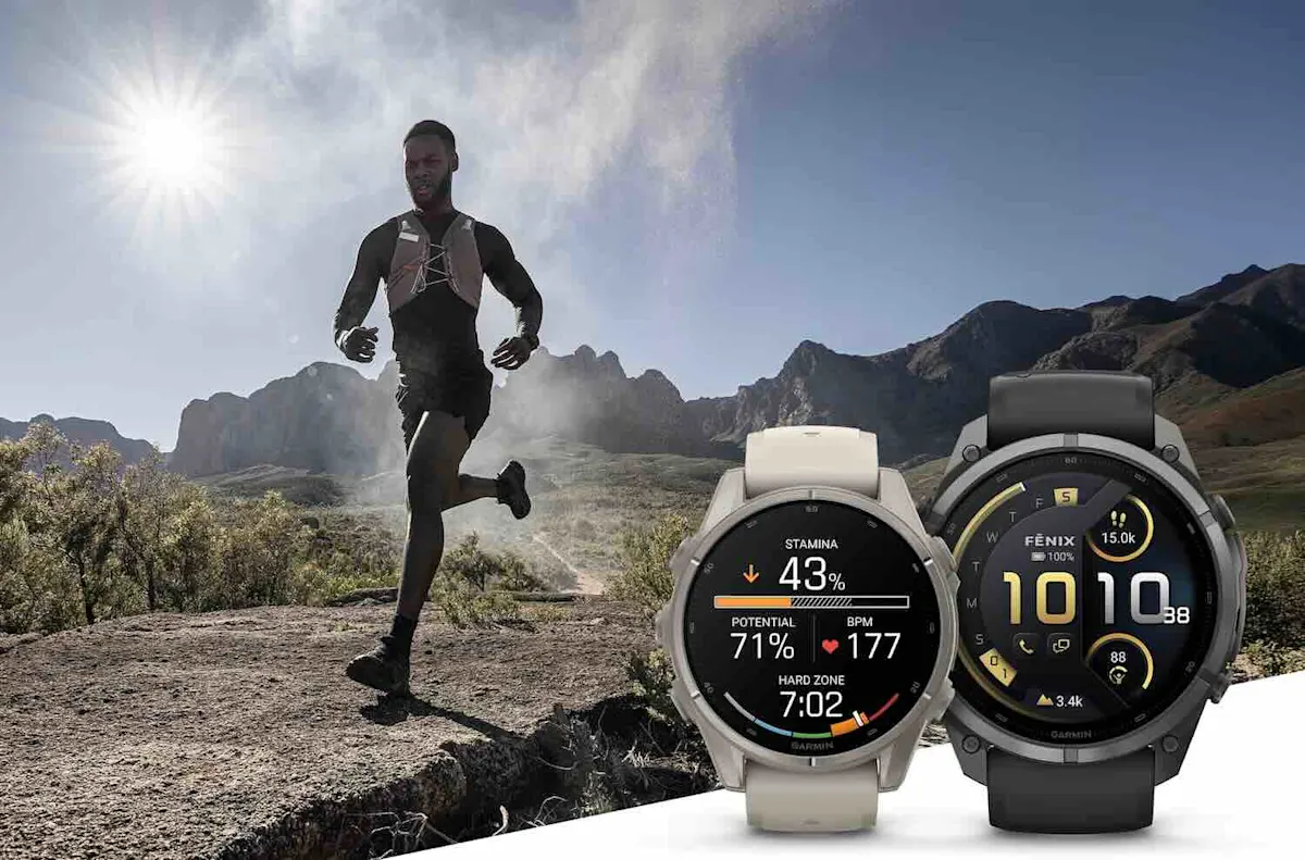 Im Hintergrund läuft ein Mann durch eine karge Landschaft. Rechts vorne sind zwei unterschiedliche Modelle der Garmin fēnix 9 aufgestellt.
