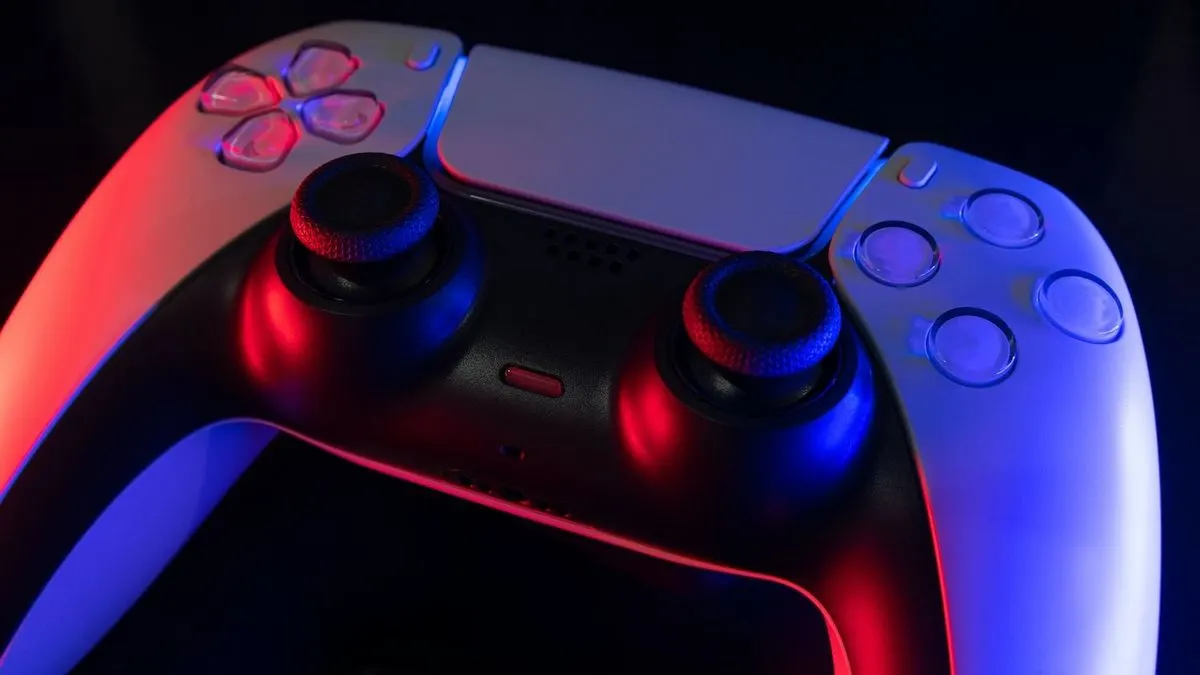 Nahaufnahme eines PlayStation Controllers liegt in buntem Licht