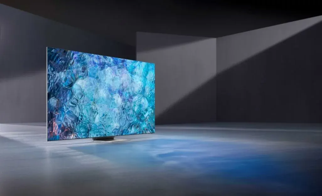 Ein TV-Gerät steht in einem Raum mit grauen Wänden und einem blauen Muster auf dem Bildschirm.