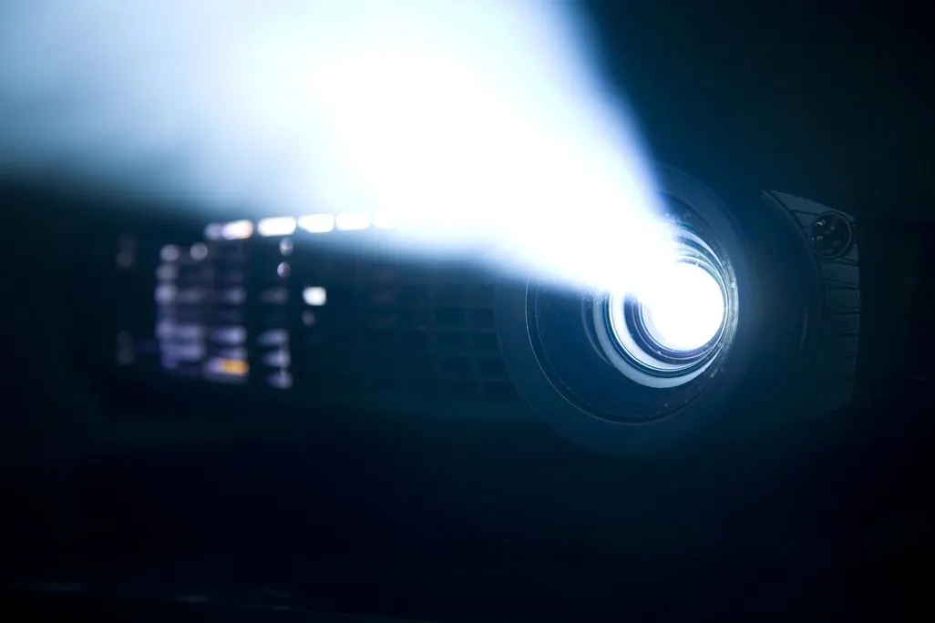 Nahaufnahme eines eingeschalteten Beamers, der einen hellen Lichtstrahl aussendet