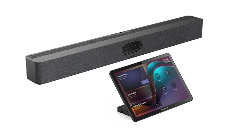 Produktaufnahme vor weißem Hintergrund: die Yealink Meetingbar A50, eine längliche dunkelgraue Soundbar mit stoffbezogener Front, mittigem Kameramodul und Belüftungsöffnungen, darüber ein schräg aufgestelltes Yealink-Touch-Controller-Tablet auf kleinem Ständer, das eine farbige Videokonferenz-Oberfläche anzeigt. Das Bild zeigt ein kompaktes Komplett-Setup für Besprechungsräume.