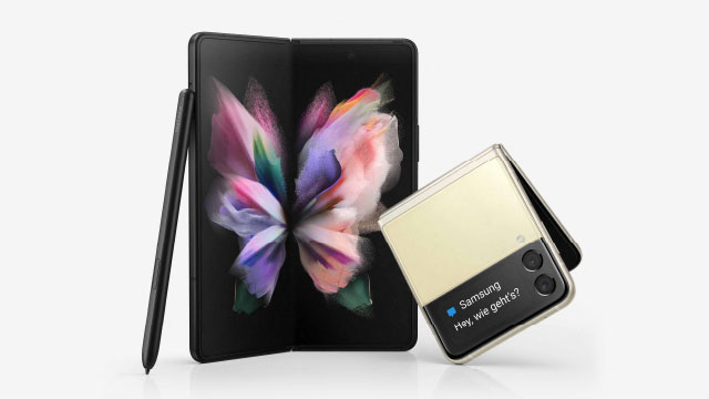 Auf einem weißen Hintergrund stehen ein schwarzes Falthandy, ein Stift und ein beiges Klapphandy mit Nachricht.