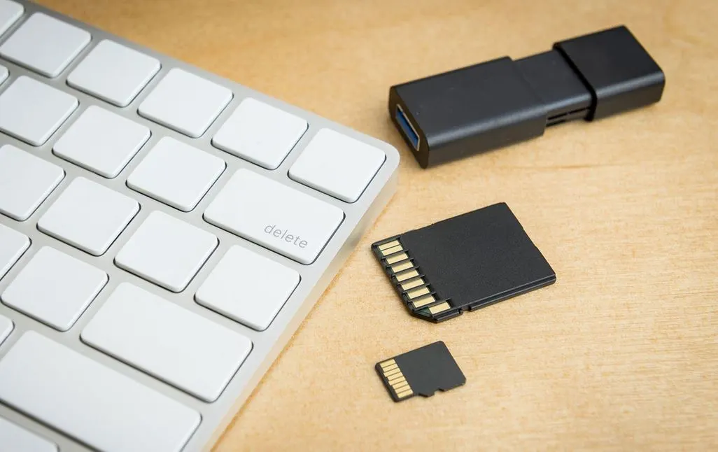 USB-Stick und verschiedene Speicherkarten neben weißer Computer-Tastatur.