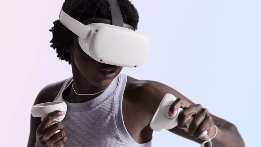Person traegt eine VR-Brille und hält zwei Controller in den Händen.