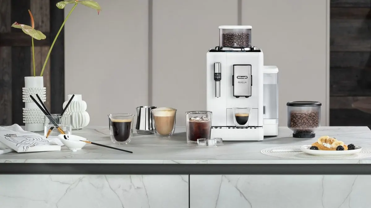 DeLonghi Rivelia auf einer Küchenarbeitsplatte mit verschiedenen Kaffeegetränken.