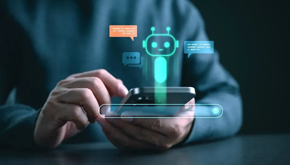 Hand hält Smartphone mit holografischem Chatbot-Interface und leuchtenden Sprechblasen, symbolisiert KI-Kommunikation und digitale Assistenz.