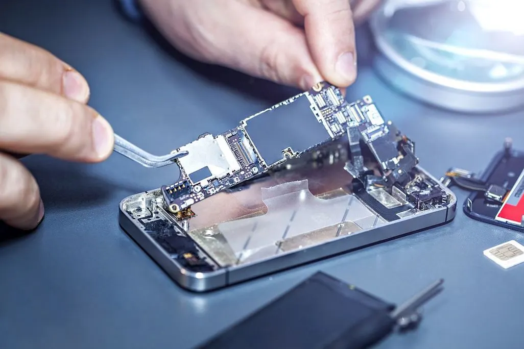 Reparatur eines Smartphones mit geoeffnetem Display und Werkzeugen