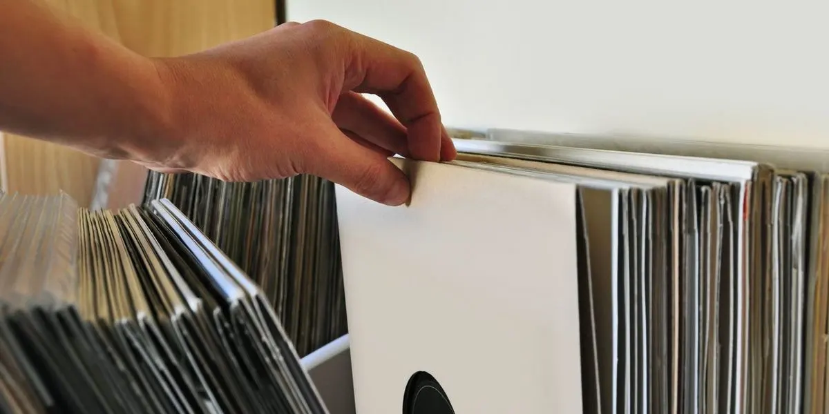 Eine Hand zieht eine Schallplatte aus einer Sammlung heraus