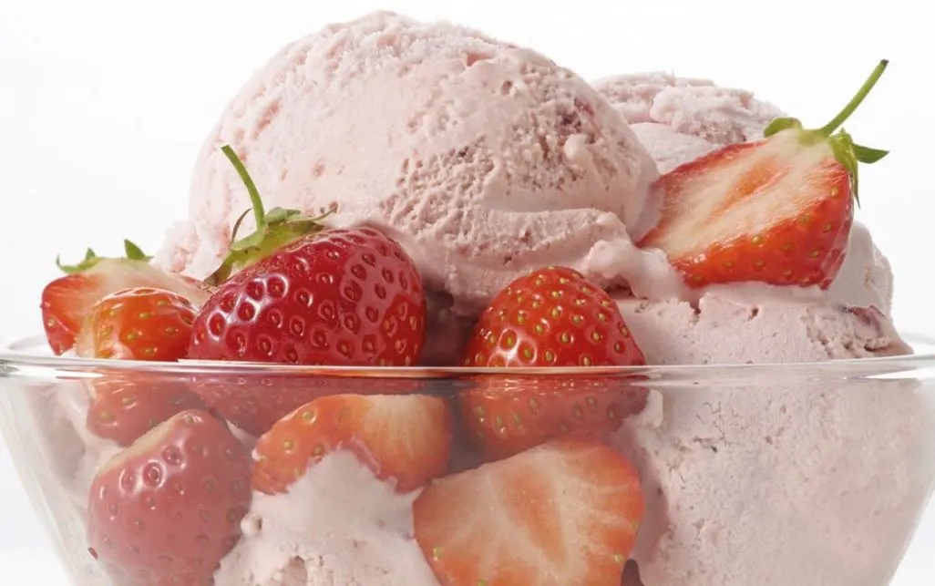 Erdbeereis mit frischen Erdbeeren in einer Glasschüssel angerichtet.