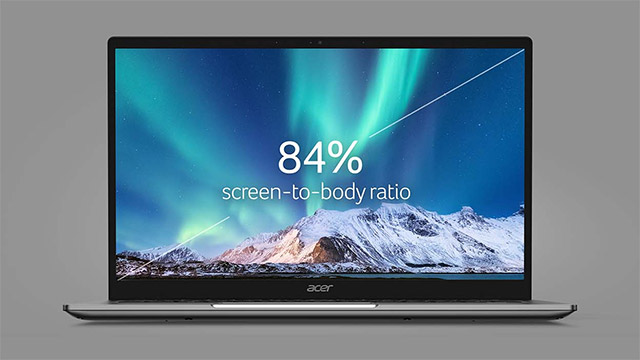 Ein Laptop steht vor einem grauen Hintergrund. Der Bildschirm zeigt ein Bergpanorama unter blauem Himmel mit Nordlichtern. "84%" ist auf dem Bildschirm zu sehen.