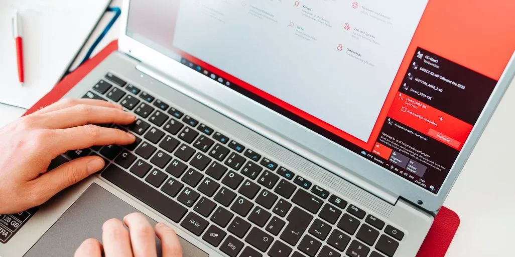 Hände tippen auf einem aufgeklappten Peaq Laptop.