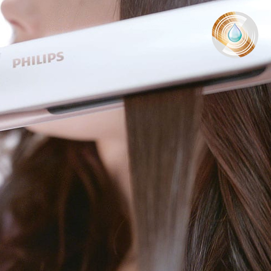 Ein weißer Philips-Haarglätter wird auf einer Haarsträhne verwendet. Das Haar ist lang.