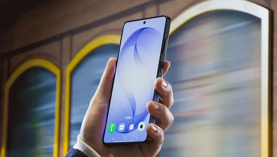 Hand mit modernem Smartphone mit nahezu randlosem Display, das vor einem bunten, vorbeirauschenden Hintergrund in die Höhe gehalten wird.