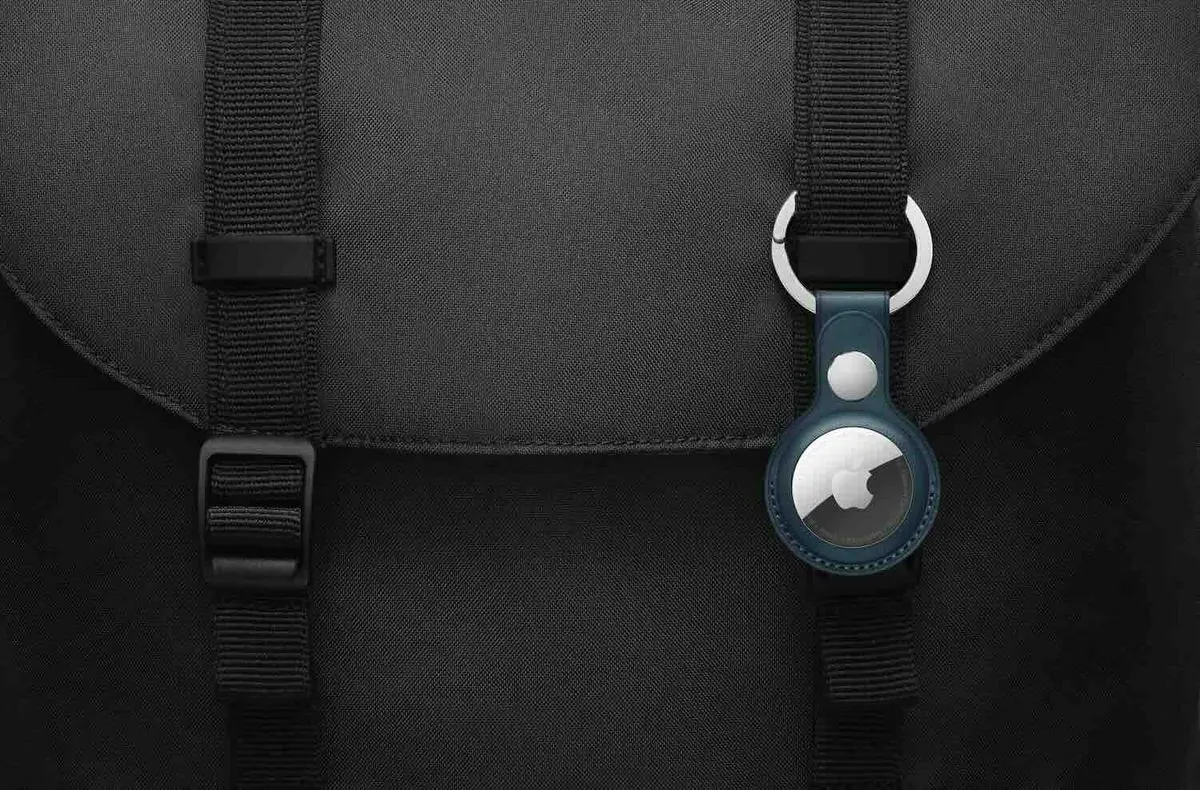 Apple AirTag in einem blauen Leder-Schlüsselanhänger, befestigt an einem schwarzen Rucksack.