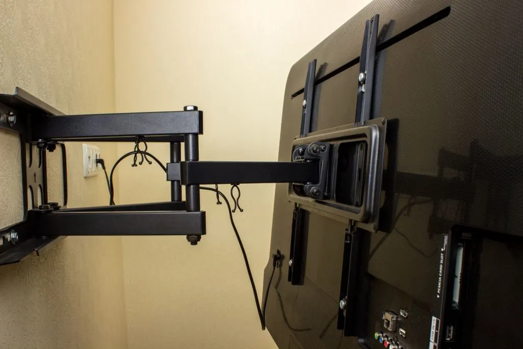 Nahaufnahme einer schwenkbaren Wandhalterung mit montiertem Fernseher.