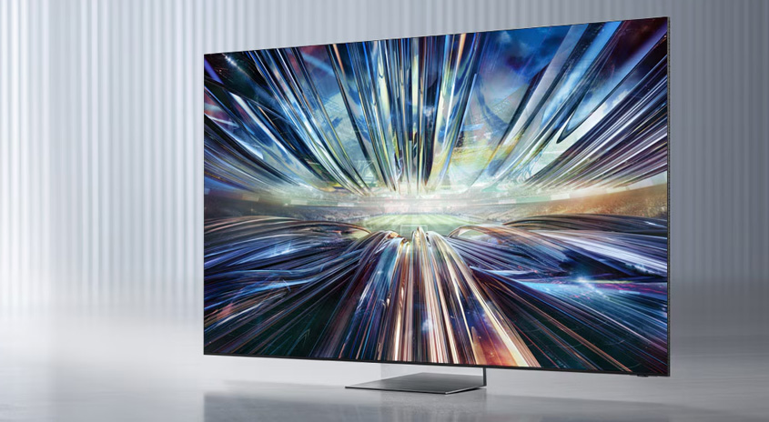 Ein Flachbildfernseher mit einem abstrakten Bild aus blauen und weißen Linien auf dem Bildschirm. Er steht auf einem silbernen Standfuß.