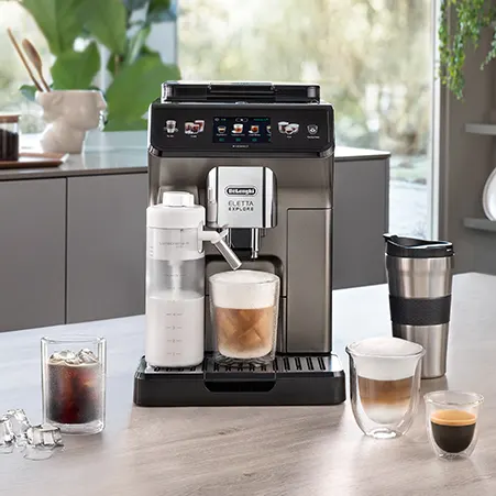 Eine graue De'Longhi-Kaffeemaschine auf einer grauen Theke mit mehreren Kaffeegetränken.
