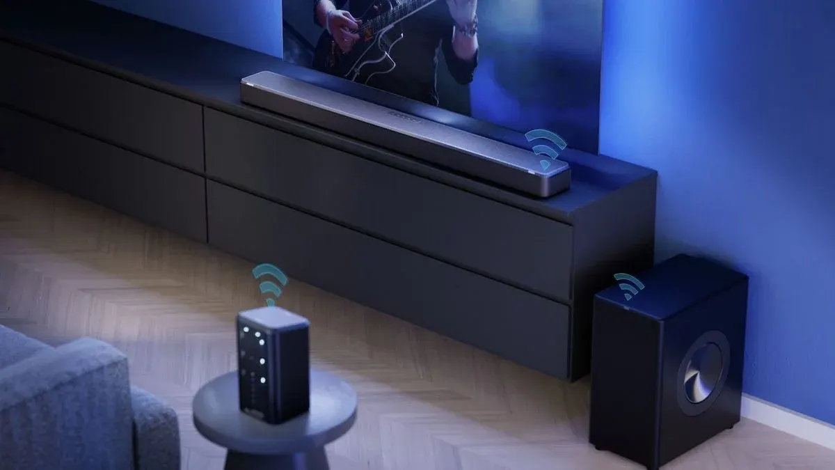 Modernes Wohnzimmer: TV mit Gitarrist, Soundbar, Subwoofer und Lautsprecher mit WLAN-Signalen auf dunklem Schrank und Parkett.