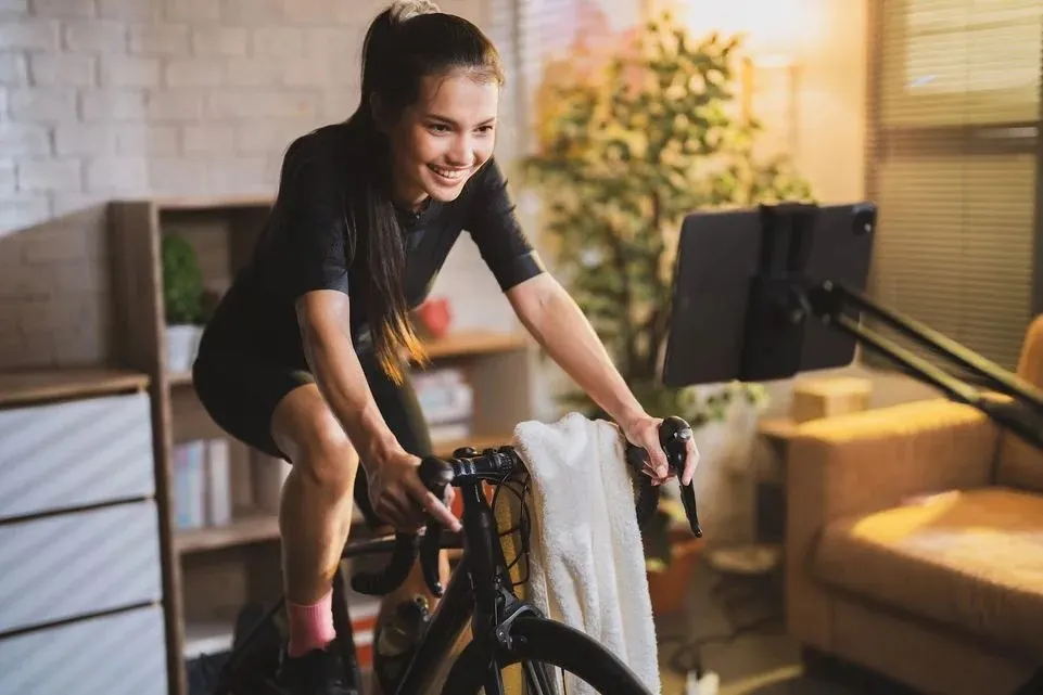 Lächelnde Frau trainiert auf einem Ergometer