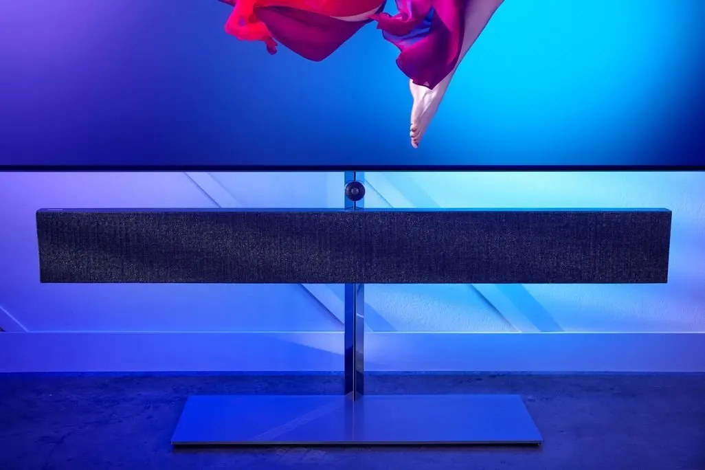 Standfuss und Lautsprecher eines Fernsehers mit blauer Ambientebeleuchtung