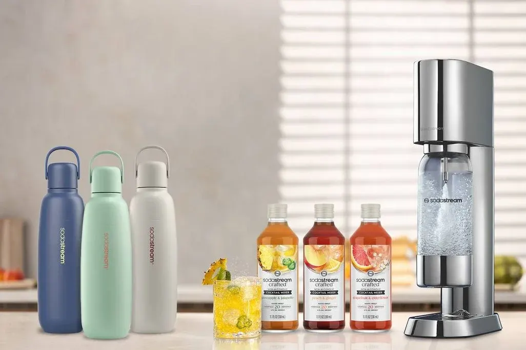SodaStream Enso mit Sirup- und bunten Trinkflaschen.