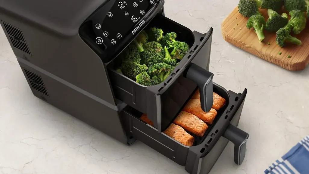 Philips 4000 Series Airfryer Stacked Dual Basket mit geöffneten Körben in denen Brokkoli und Lachs liegt.