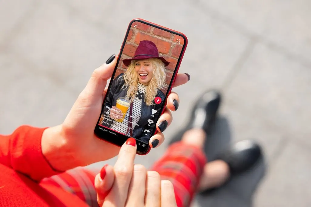 Person nutzt Smartphone für Video-Chat oder Social Media App mit Filter-Effekten.