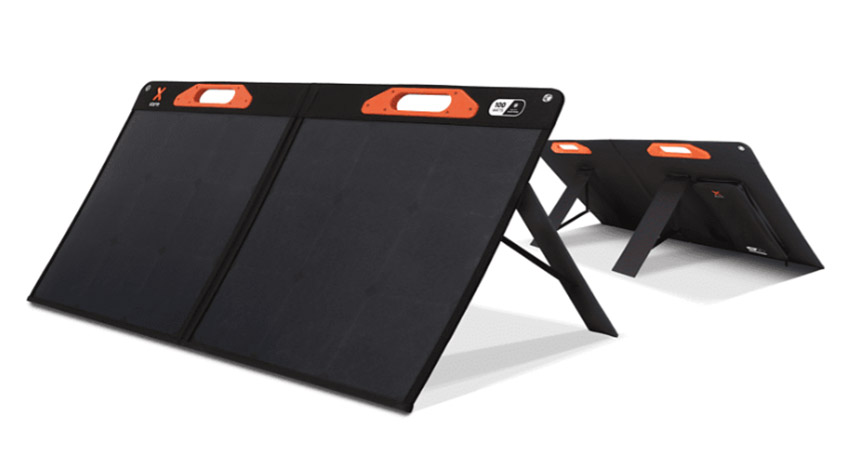 Zwei schwarze, faltbare Solarmodule stehen auf einem weißen Untergrund. Orangefarbene Griffe sind an der Oberseite befestigt.