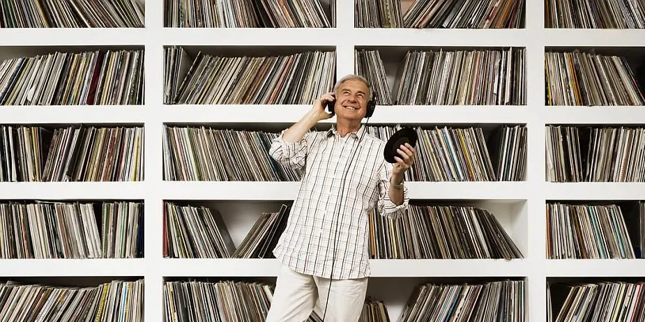 Person steht vor einem Regal voller Schallplatten und telefoniert.