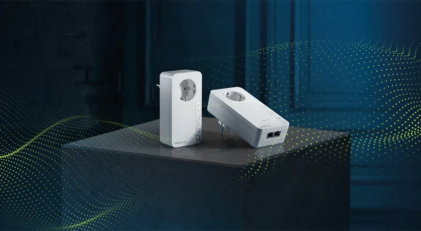 Zwei weiße Adapter mit Steckdosen auf einem dunklen Sockel, vor einem blau-schattierten Hintergrund mit gelben Punktmustern.