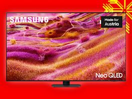 TV-Gerät auf rotem Hintergrund, dekoriert mit gelber Schneeflocke in der Ecke.